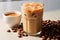 Refreshing iced coffee with milk and coffee beans on marble table, morning beverage concept