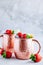 Refreshing iced Moscow mule alcoholic cocktail in copper mugs with strawberry and lemon