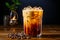 Refreshing and invigorating cold coffee with milk and ice on a dark background in a transparent glass. Nearby coffee