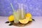 A refreshing lemon drink and ripe lemons on a  light blue  background.