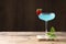 Refreshing light blue cocktail on wooden table, space for text