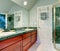 Refreshing light green bathroom with bright brown cabinets