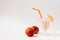 Refreshing milkshake with nectarine and orange straws on a light background with nectarines lying next to it