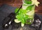 Refreshing mojito with rum, fresh lime, mint, crushed ice and carambola on a dark wooden background. Summer and alcohol beverage.