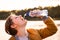 Refreshing Moment: Young Caucasian Girl Savoring Water Outdoors