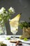 Refreshing Pear cocktail lemonade in a glasse with pear puree and fresh fruit and flowers on light gray table background