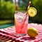 Refreshing Pink Lemonade with Striped Straw on Picnic Table