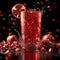 Refreshing pomegranate drink splashing in glass surrounded by whole and cut fruit. vivid red beverage concept with copy