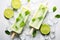 Refreshing Popsicles With Limes and Mints on Ice for a Cool Treat, Lime ice cream popsicles presented with lime slices and mint on