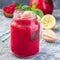 Refreshing raspberry, lemon and mint lemonade with sparkling water in a jar, square format