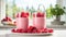 Refreshing raspberry milkshake in clear glass on clean white kitchen counter with sunlight