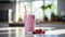 Refreshing raspberry milkshake in clear glass on pristine white kitchen counter with sunlight
