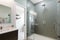 refreshing shower in stylish bathroom with lofi wallpaper, glass tile and sleek fixtures
