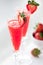 Refreshing strawberry Mimosas garnished with fresh cut strawberries.