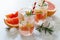 Refreshing summer drink with grapefruit and rosemary on a stone background.