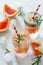 Refreshing summer drink with grapefruit and rosemary on a stone background.