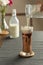 Refreshing summer drinks or beverages, chocolate cocoa latte with chocolate sauce and cold foam milk on top in a tall glass