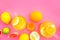 Refreshing summer tea with fruits. Teacup and teapot near orange, lime, lemon, grapefruit on pink background top view