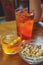 Refreshing traditional drinks on wooden table Aperol Spritz and sparkling water.