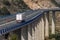 Refrigerated truck driving over a long bridge