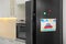 Refrigerator with child`s drawing and magnets in kitchen