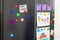 Refrigerator with child`s drawings, notes and magnets, closeup