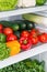 Refrigerator shelves organized with vibrant fresh vegetables.