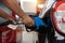 Refueling the car at a gas station fuel pump. Man driver hand refilling and pumping gasoline oil the car with fuel at he refuel