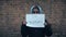 Refugee girl with an inscription on a white sheet