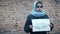 Refugee girl with an inscription on a white sheet