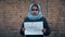 Refugee girl with an inscription on a white sheet