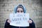 Refugee girl with an inscription on a white sheet