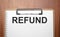 REFUND text on white paper on the wood table