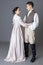 A Regency couple in a romantic embrace against a grey backdrop