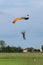 Reggio Emilia, Italy - May 2017: Parachutist with Orange Parachute against Clear Blue Sky