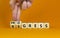 Regress or progress symbol. Businessman turns wooden cubes and changes the word `regress` to `progress`. Beautiful orange tabl