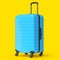 Regular blue polycarbonate suitcase isolated on yellow background.