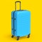 Regular blue polycarbonate suitcase isolated on yellow background.