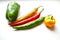 Regular and capsicum yellow and green pepper on a white background