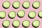Regular seamless creative pattern of cucumber slices on a pink background.