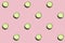 Regular seamless creative pattern of cucumber slices on a pink background.