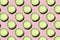 Regular seamless creative pattern of cucumber slices on a pink background