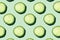 Regular seamless pattern of cucumber slices on a pastel mint background