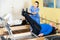 Rehabilitation physician controlling senior man exercising on pilates reformer