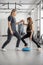 Rehabilitation specialist helping little girl to do exercises at gym