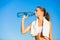 Rehydrating after a long workout. Shot of a beautiful young woman drinking water after her workout.