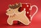 Reindeer vanilla cookie biscuit with red polka dot cup of coffee close up