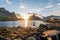 Reine Lofoten Islands in Norway during sunset. Sunbeams/burst fills the blue sky during summertime.