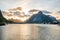 Reine in Lofoten Islands in Norway during sunset. Warm tones and colors fills the cloudy sky during summertime.