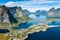 Reine Lofoten Norway, aerial view of Norwegian traditional fishing village above polar circle with blue sea and mountains during